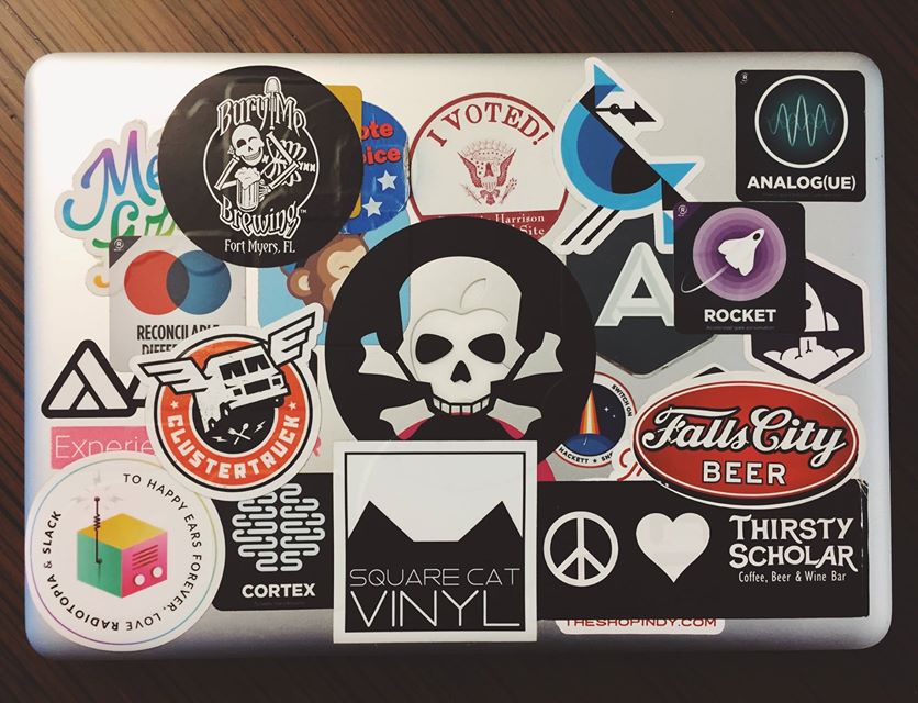 A picture of a late 2013 MacBook Pro, covered in stickers (many of popular Indianapolis haunts).